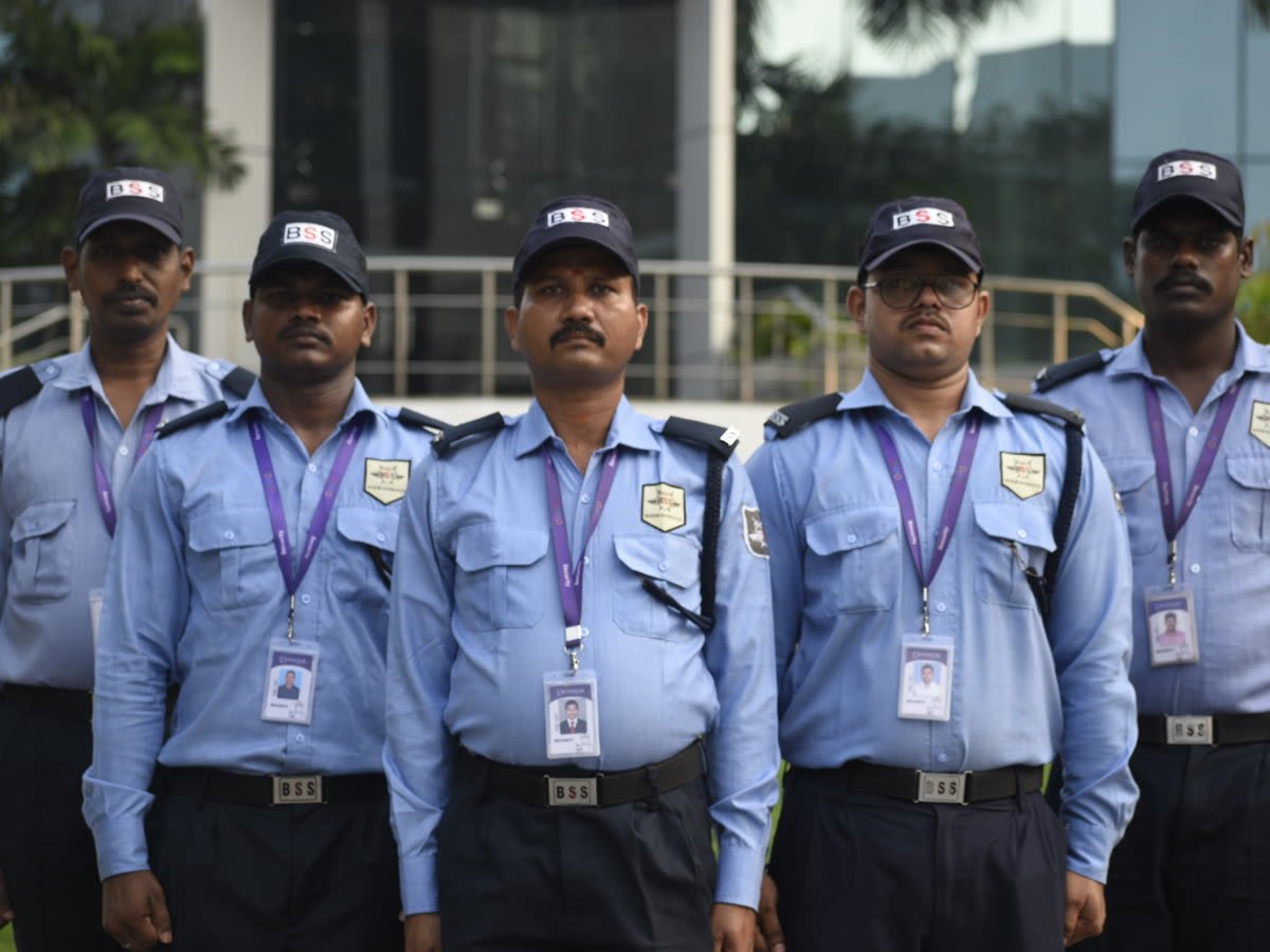 Five BSS security guards in uniform with ID cards, standing in a line